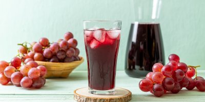 Sklenice s hroznovou šťávou a ledem, karafa s hroznovou šťávou, hrozny