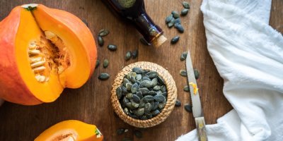 Rozřízlý dýně hokkaidó, dýňová semínka a olej z dýně