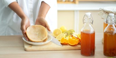 Žena drží na prkénku kombuchu