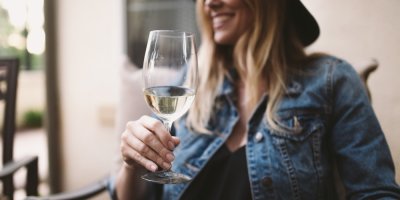 Žena pije bílé víno