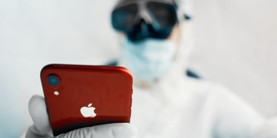 Muž v ochranném oděvu drží iPhone