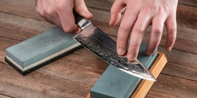 Ruce brousí nůž na kameni