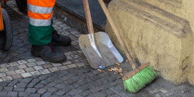 Muž uklízí nedopalky na ulici