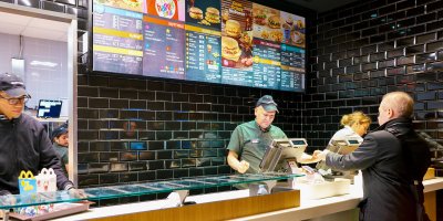 Člověk si objednává u pokladního jídlo v McDonald’s