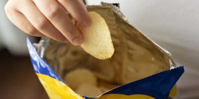 Člověk vytahuje chips z balení