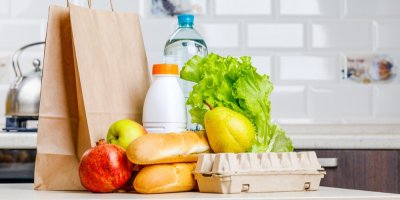 Nákup v podobě baget, mléka, vajec, zeleniny a ovoce na kuchyňské lince