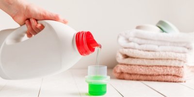 Žena lije prací prostředek do víčka