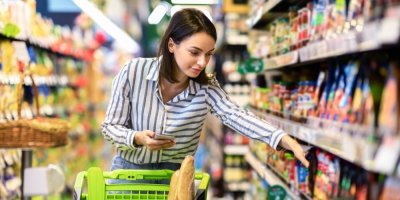 Žena s vozíkem nakupuje v supermarketu