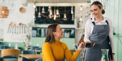 Žena platí kartou v restauraci