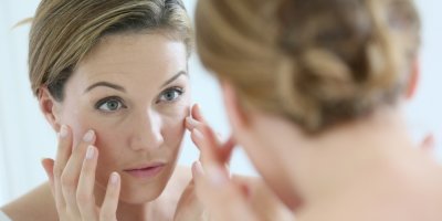 Žena středního věku se prohlíží v zrcadle