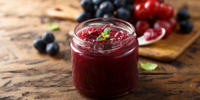 Hroznový džem ve sklenici, v pozadí hrozny