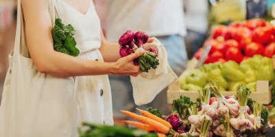Žena si vybírá zeleninu na farmářském trhu