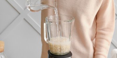 Žena zalévá ovesné vločky v mixéru vodou