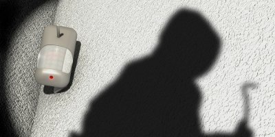 Detektor pohybu a stín zloděje na zdi