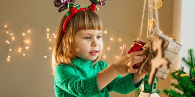 Holčička otevírá balíček zavěšený na šňůrce