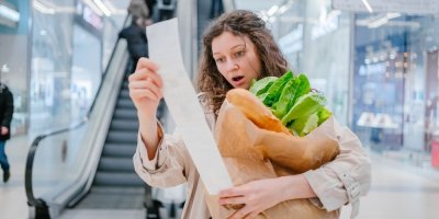Žena se překvapeně dívá na dlouhou účtenku