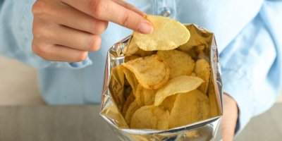 Člověk konzumuje chipsy