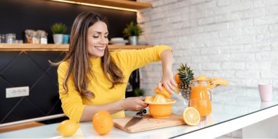 Žena vyrábí pomerančový džus