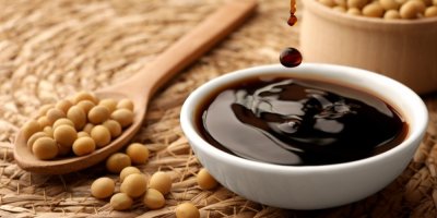 Sójová omáčka v misce, vzadu sójové boby