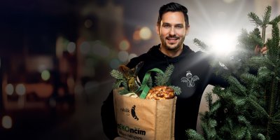 Kurýr Rohlík.cz nese nákup a vánoční stromeček