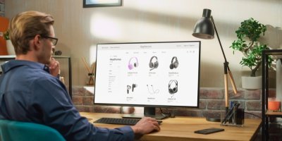 Člověk si na počítači prohlíží e-shop, na kterém se prodávají sluchátka