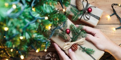 Ukládání vánočních dárků zabalené s přírodninami pod stromeček