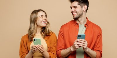 Muž a žena drží v ruce mobilní telefony