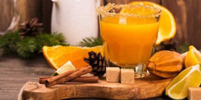 Horký nápoj ve skleničce a okolo citrusy a skořice