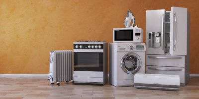 Lednice, pračka, na které je mikrovlnka s žehličkou, dále trouba, radiátor, klimatizace