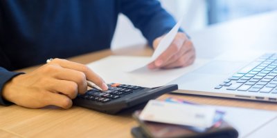 Muž počítá na kalkulačce