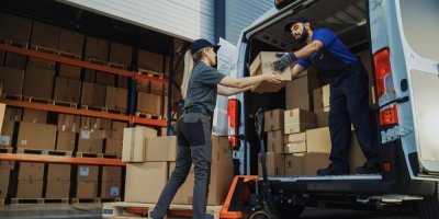 Žena si přebírá balík od dopravce