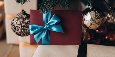 Dárkově zabalená obálka pod vánočním stromkem