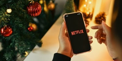 Ruka drží mobil u vánočního stromečku