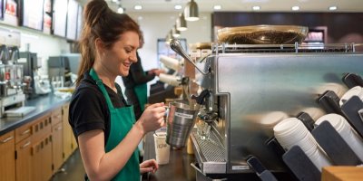 Barmanka připravuje kávu v obchodu Starbucks