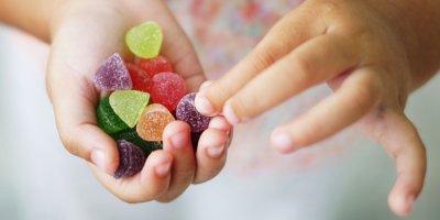 Holčička drží v rukách bonbony