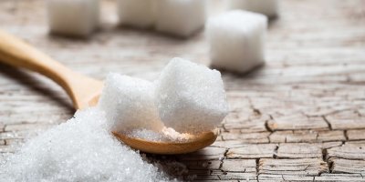 Kostky cukru a cukr krystal na dřevěné lžíci