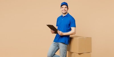 Kurýr opřený o balíky