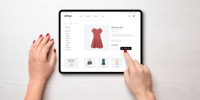 Ruce ťukají na tablet, kde je otevřená webová stránka s e-shopem
