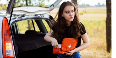 Žena drží autolékárničku vzadu u auta