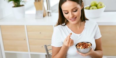 Žena jí oříšky, které má v misce
