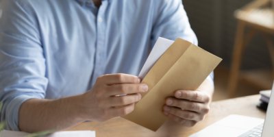 Muž držící obálku