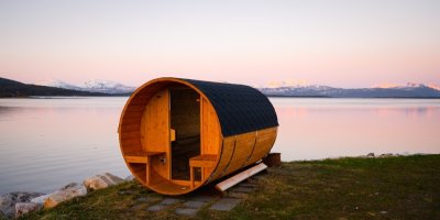 Dřevěná sauna u jezera, v pozadí hory