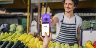 Muž platí mobilem u zelináře