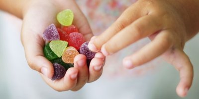 Dítě drží v dlani gumové bonbony
