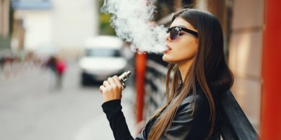 Mladá žena kouří elektronickou cigaretu