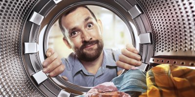 Muž kouká do bubnu pračky