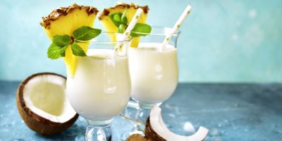 Dva koktejly Virgin Colada ve sklenicích, zdobených ananasem a mátou