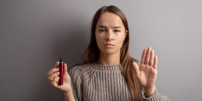 Mladá žena drží elektronickou cigaretu