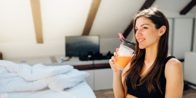 Žena ve sportovním oblečení pije nápoj