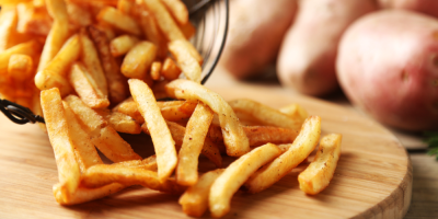 Záběr na hranolky vysypané na dřevěném podnose